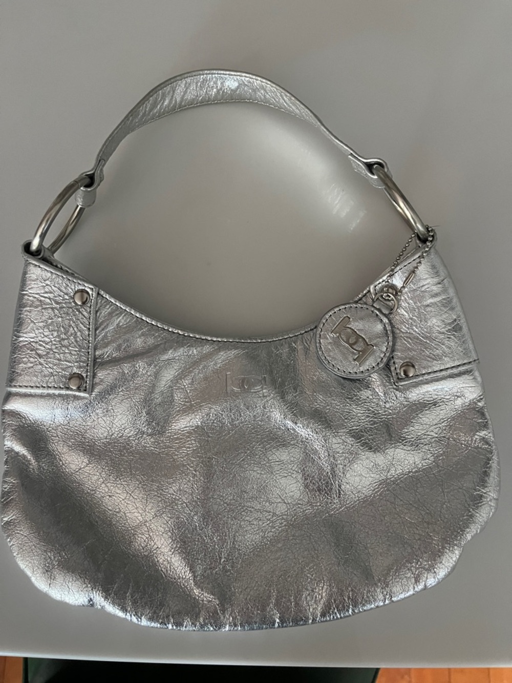 bebe Silver Metallic Shoulder Hobo with Logo Charm